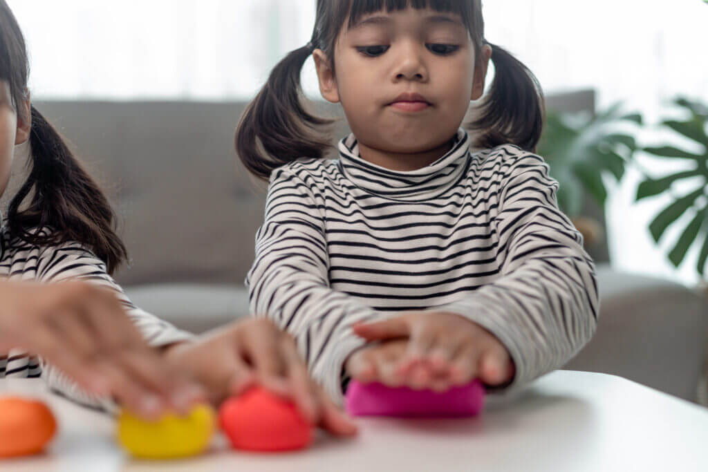 Kids playing with clay and molding shapes