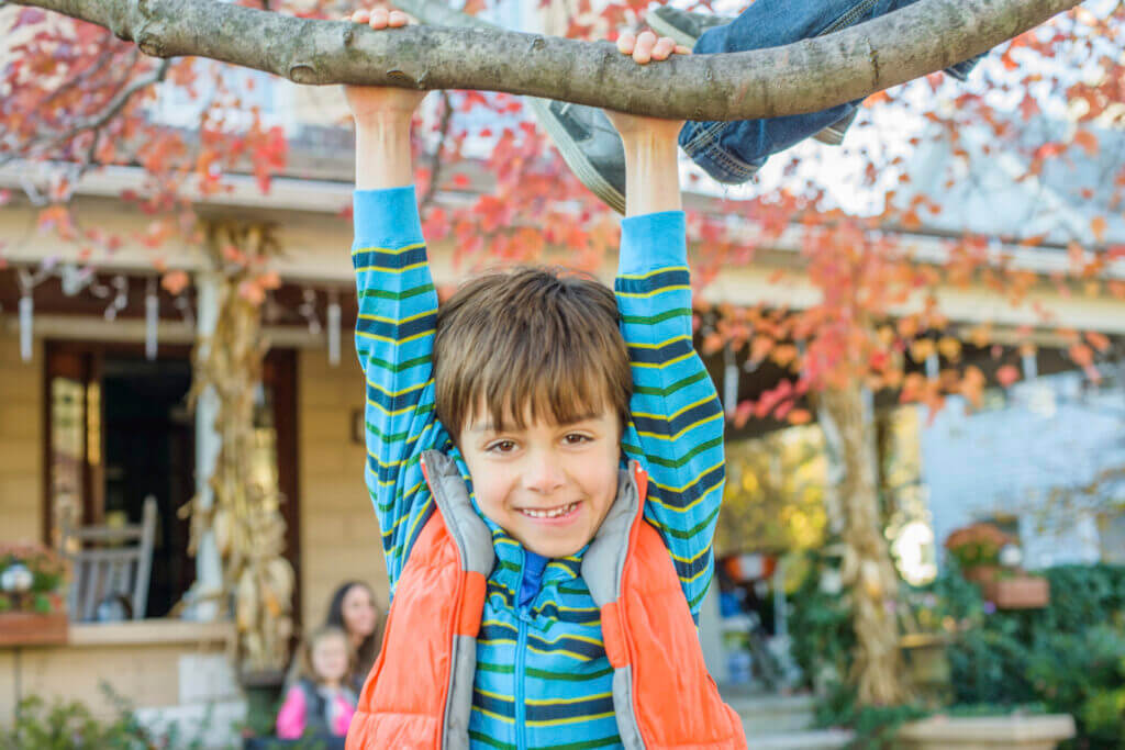 Boy hanging upside down from a branch