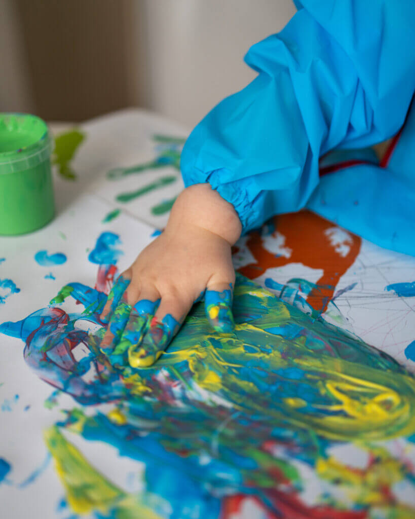 Child finger painting with bright colors